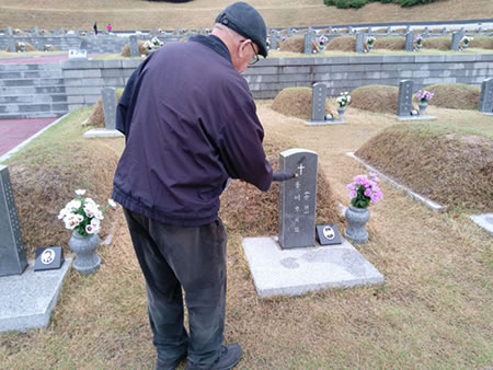 Fr. O'Grady at the grave of a Catholic victim of the Gwangju Massacre