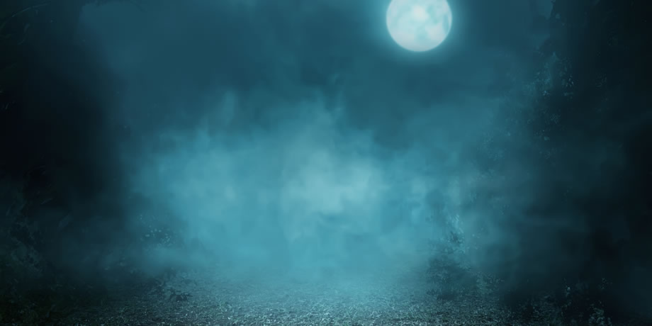The moon peeks through a dark cloudy night
