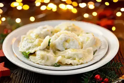 Christmas dumplings stuffed with mushroom and cabbage on a white plate.