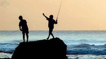 Children fishing from a rock