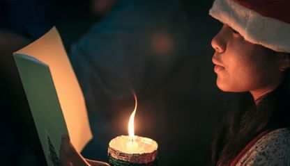 Festive Christmas singer with candle and songbook