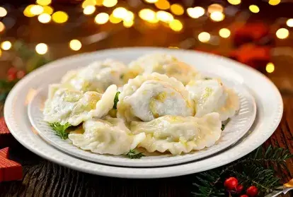 Christmas dumplings stuffed with mushroom and cabbage on a white plate.