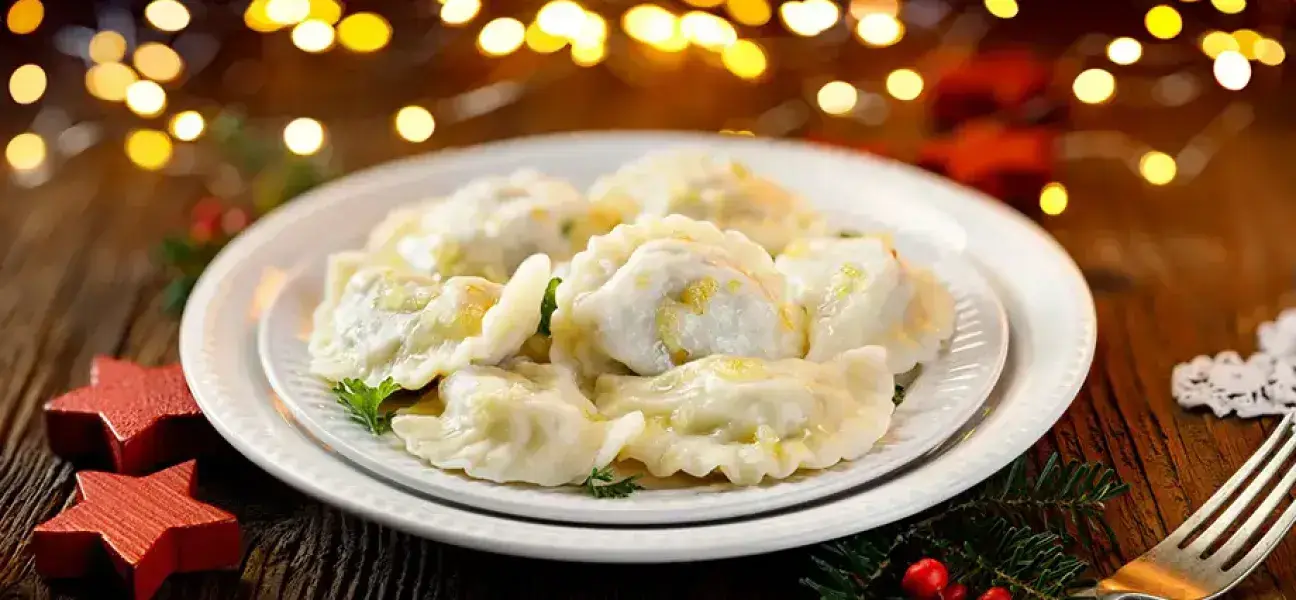 Christmas dumplings stuffed with mushroom and cabbage on a white plate.
