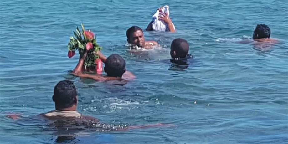 People in the water return person's ashes to the sea.