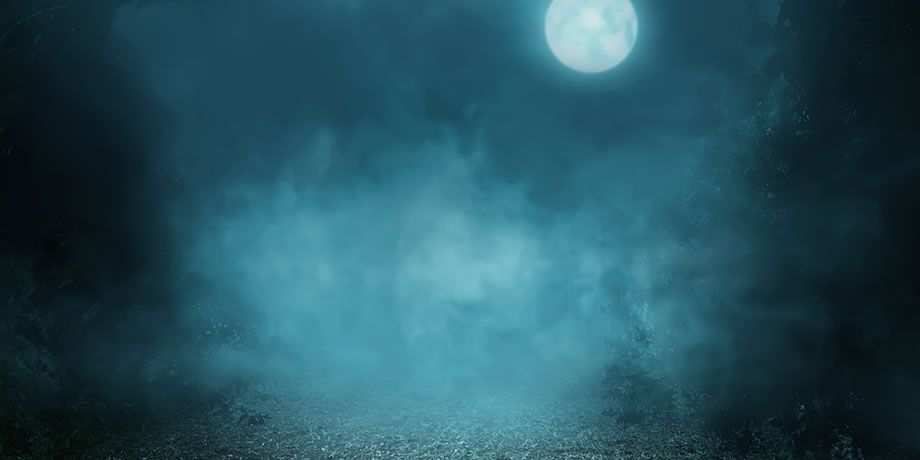 The moon peeks through a dark cloudy night