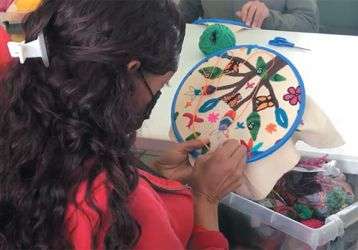 Migrant woman emproidering