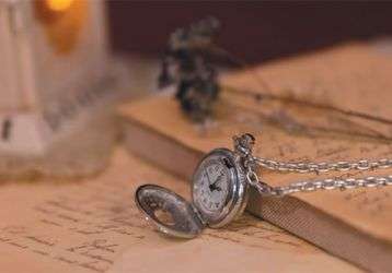 A watch, candle and letters on a desk