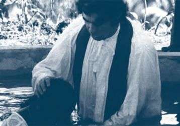 Fr. Frank Hoare baptizing by immersion, 1976