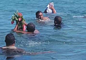 People in the water return person's ashes to the sea.