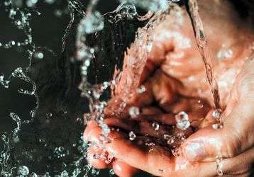 Water running into cupped hands.