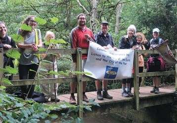 Christian walkers with a banner on a woodmen foot bridge